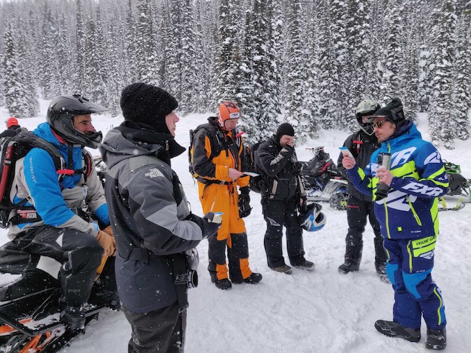 Grant Helgeson interacts with backcountry snowmobilers at Quartz Creek, near Golden, BC.