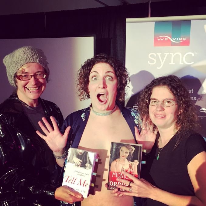Here I am with Keely Kamikaze, the founder/producer of the Naked Girls Reading Calgary Chapter (now rebranded Bare Books Club), and fellow romance author Alyssa Linn Palmer at the Taboo Show in 2017, where Keely read from Tell Me and Alyssa’s Midnight at the Orpheus.