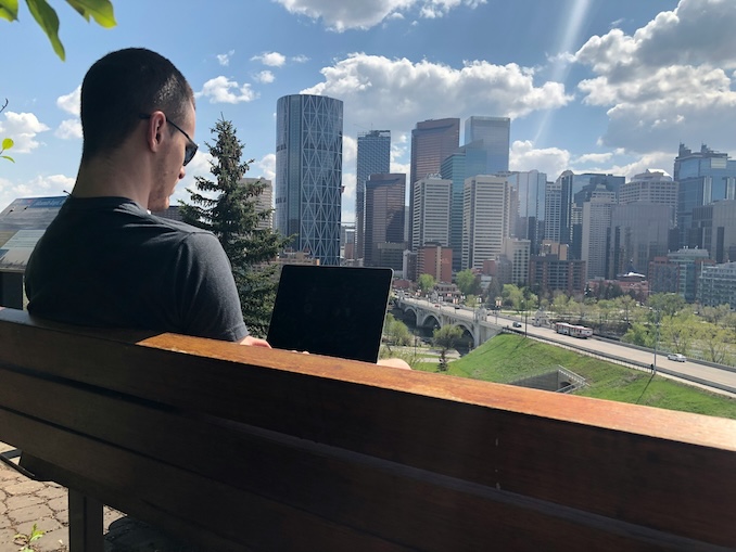 guy on his laptop looking over the view of Calgary's skyline.