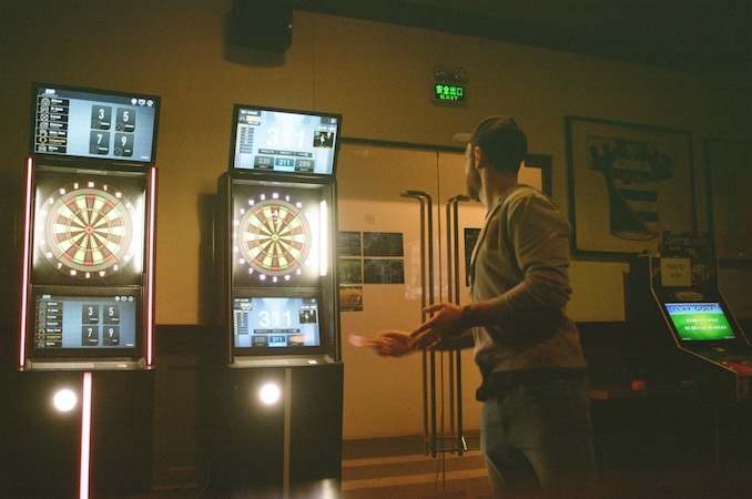 guy playing darts on an electronic dart board.