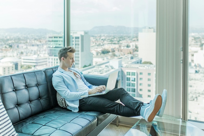 guy sitting on the couch using his laptop