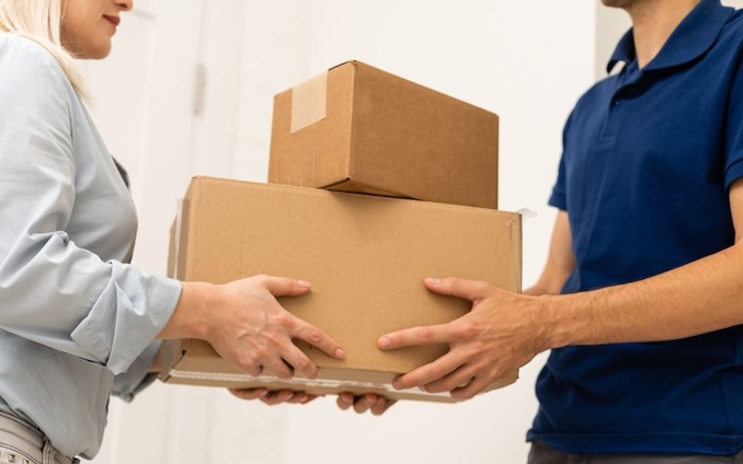 Two people passing boxes