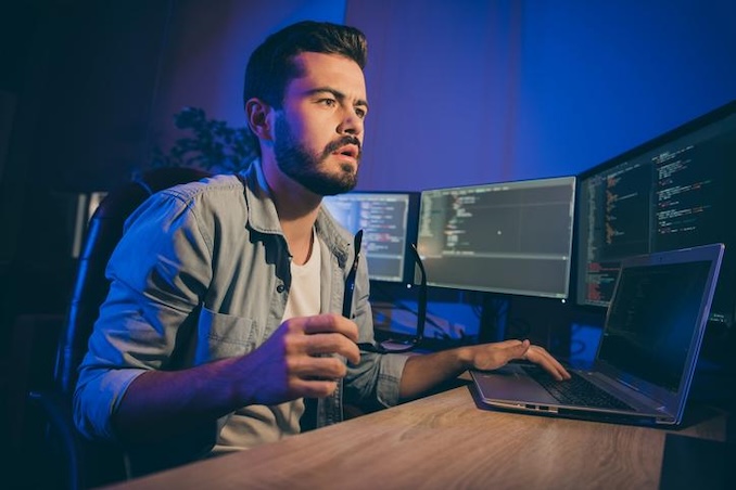 man using his computer with a blue background