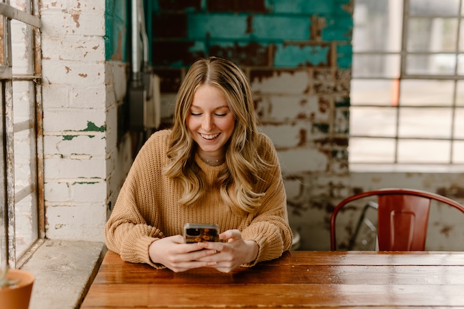 woman using her cellphone at a table in an industrial building