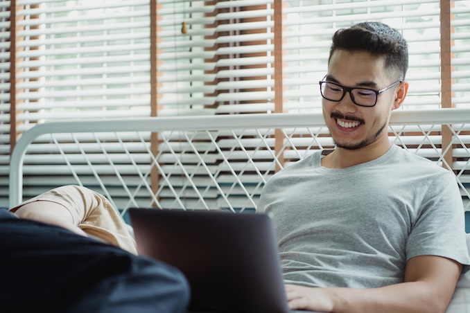 man laughing on his laptop