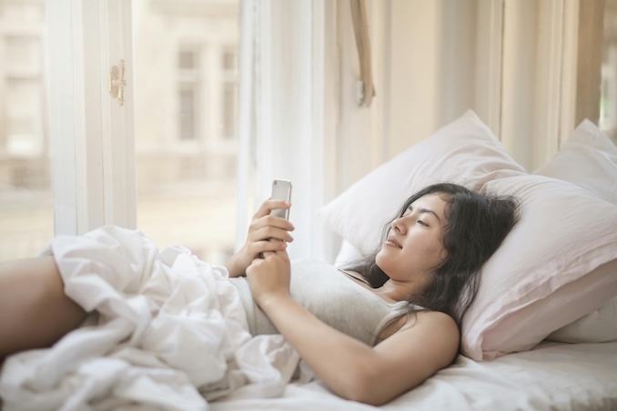 Woman on her phone in bed