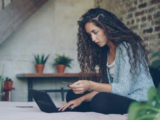 women in bed on laptop
