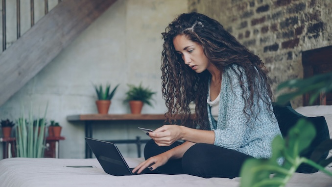 women in bed on laptop
